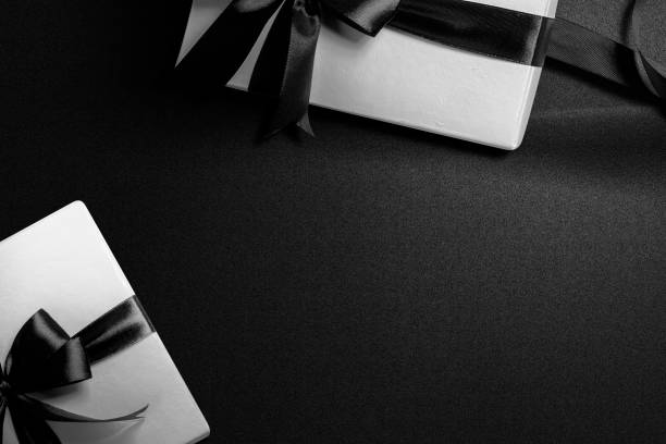 istock White gift box with a black ribbon with a black background 1359095398