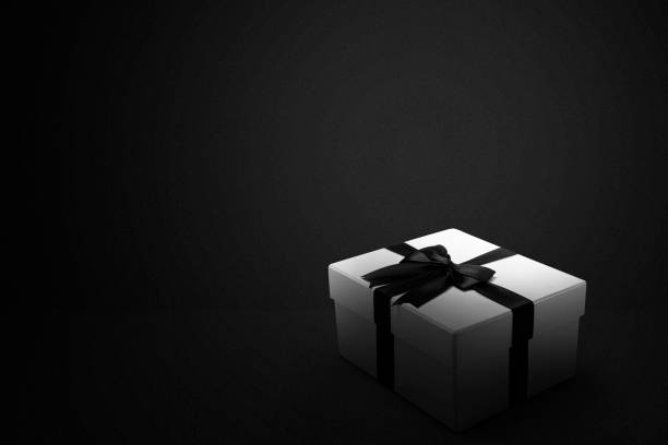 istock White gift box with a black ribbon with a black background 1359095436