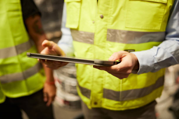 istock Close-up view of hands holding a digital tablet in a warehouse. 1359096435