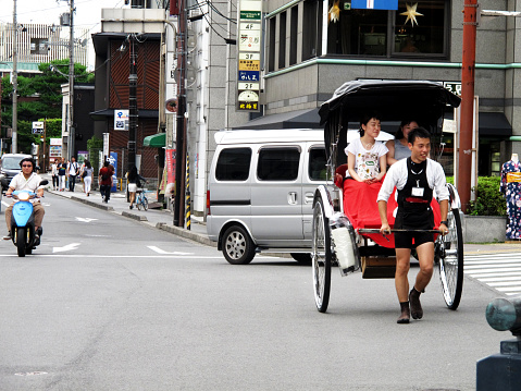 Classic antique vintage retro rickshaw trishaw bicycle for japanese people and foreign traveler passenger journey on Hanamikoji Street of Gion old town at Kyoto city on July 11, 2015 in Kansai, Japan