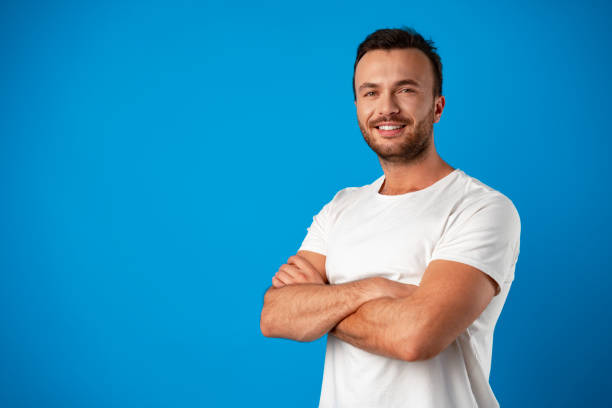 istock Happy smiling handsome man against blue background 1359098382