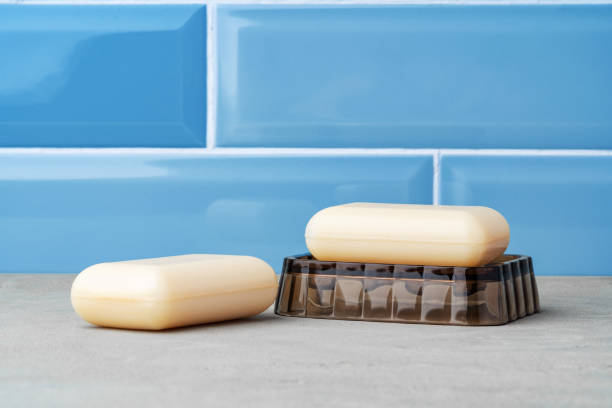 barra de jabón blanco sobre plato de plástico en baño azul - jabonera fotografías e imágenes de stock