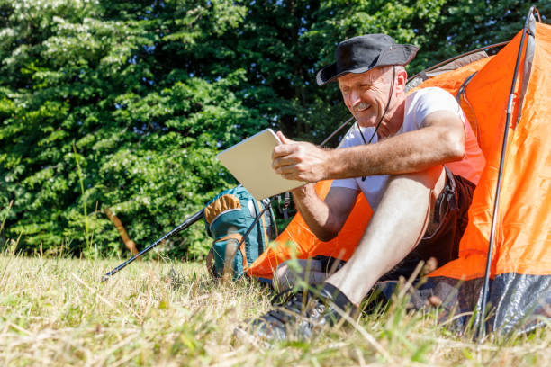 istock Senior camper working online via digital tablet 1359102578