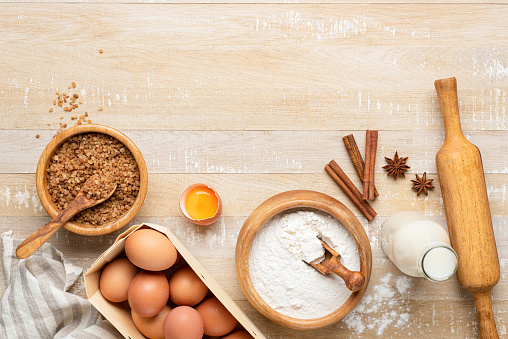 Ingredients for baking a cake on wooden table background, flat lay, copy space for text recipe or design