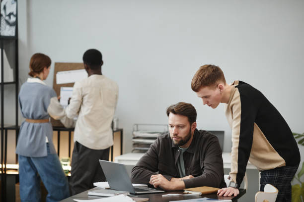 istock Designer talking to his colleague at office 1359104127