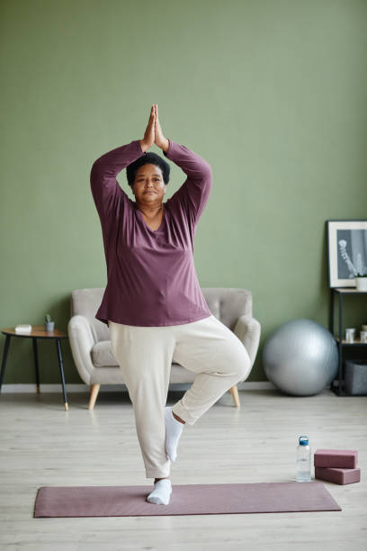 afroamerykańska seniorka uprawiająca jogę w domu - healthy lifestyle yoga vitality flexibility zdjęcia i obrazy z banku zdjęć