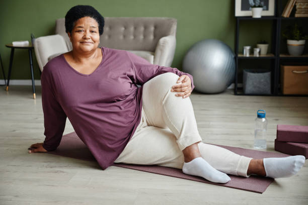 porträt einer schwarzen seniorin beim training - floor women sitting yoga stock-fotos und bilder