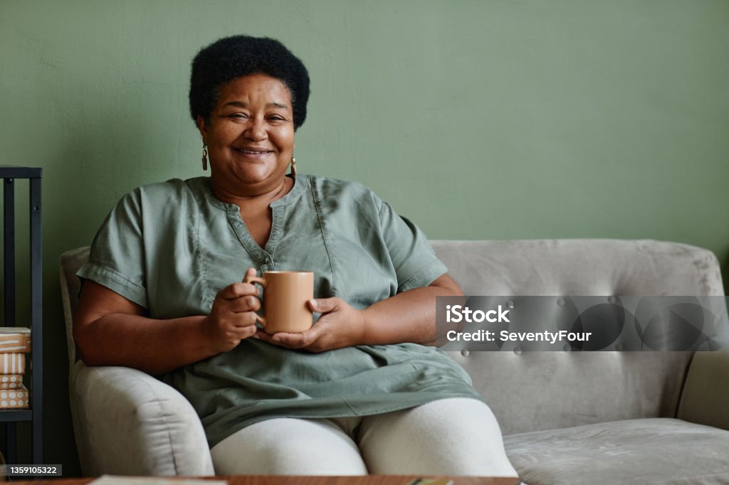 Black Senior Woman Enjoying Coffee Portrait of black senior woman smiling at camera while enjoying cup of coffee at home, copy space Senior Adult Stock Photo