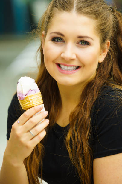 istock Young woman eating ice cream 1359105638