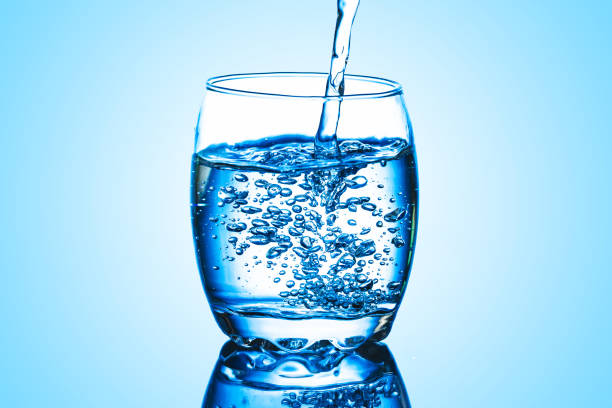 istock Mineral water background. Pouring water into glass. 1359109920