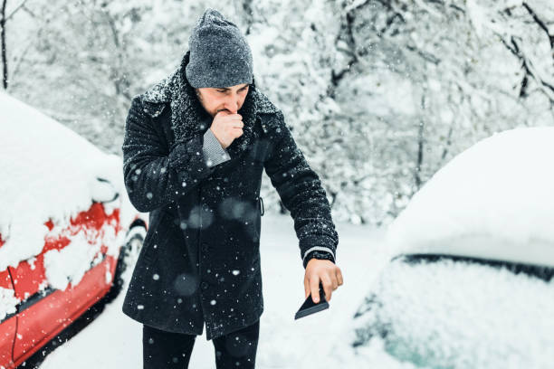 istock Man cleans car glass from ice 1359110170