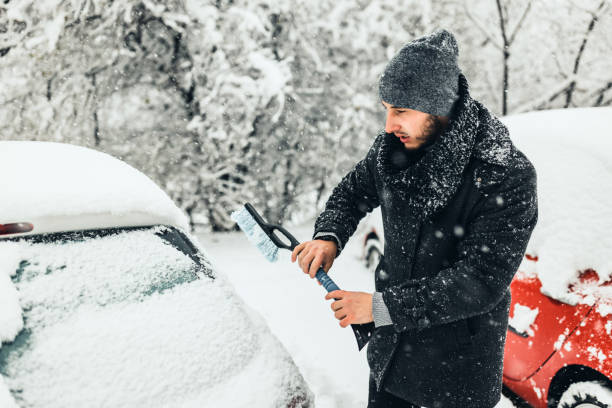 istock Man cleans car glass from ice 1359110186