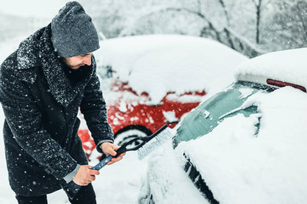 istock Young Man cleans car glass from ice 1359110187