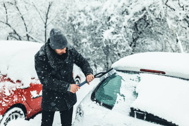 istock Young Man cleans car glass from ice 1359110197