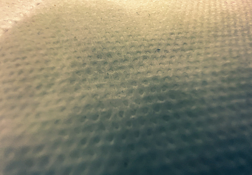 A macro image of a white fabric with patterns.