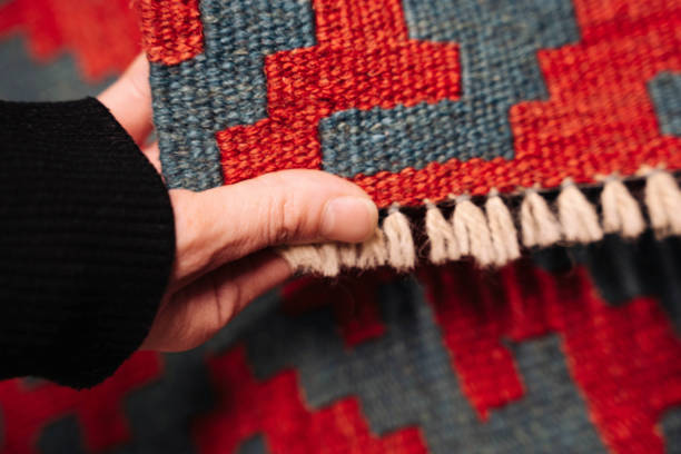 istock a woman's hand selects and touches a colored carpet in a store 1359112527