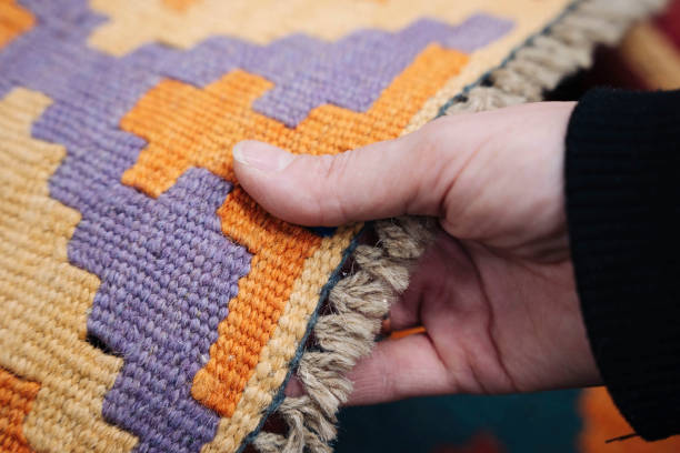 istock a woman's hand selects and touches a colored carpet in a store 1359112531