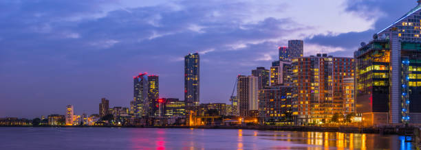 appartements modernes de haute hauteur en ville illumunés au crépuscule panorama sur le front de mer - illumunated photos et images de collection