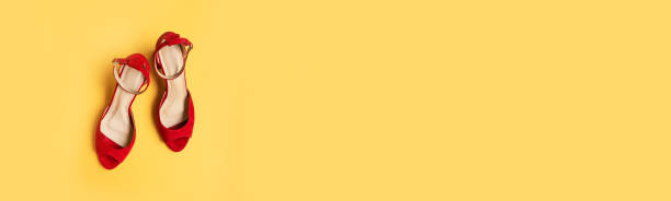 istock Red female shoes on yellow background. Flat lay, top view 1359112746