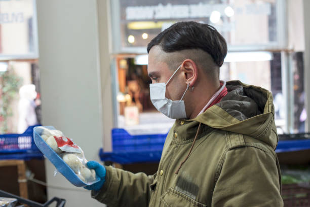 istock A man wearing a protective mask buying mushrooms 1359115165