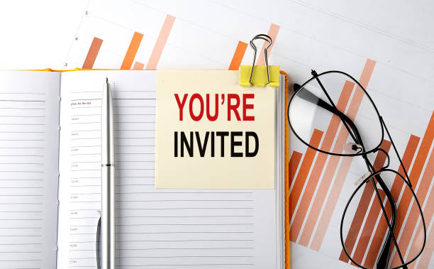 istock Text YOU'RE INVITED on sticker on the notepad on diagram background 1359115284