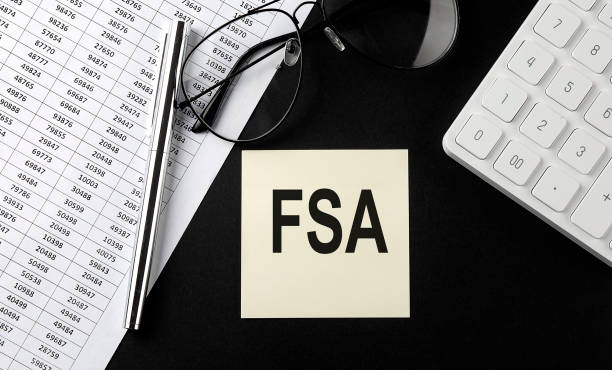 istock Concept FSA message on sticker with glasses,chart and calculator on the black background 1359115301