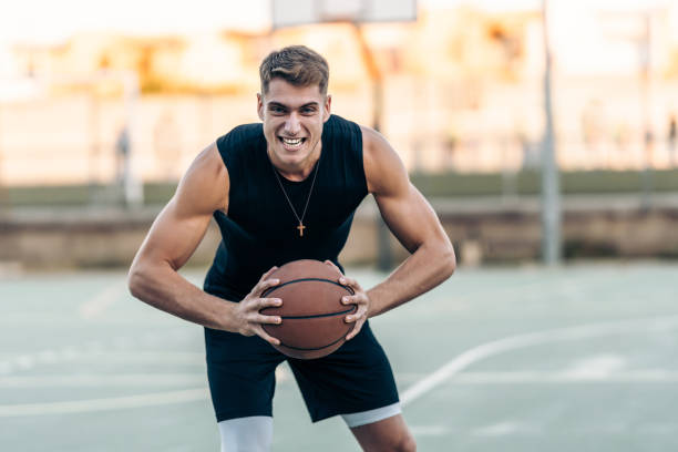 istock Man posing with aggressive expression while holding a basketball outdoors 1359116288