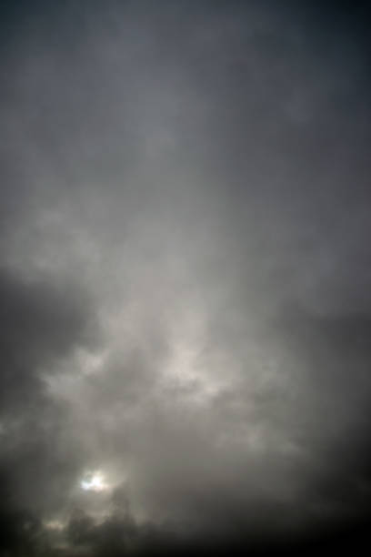 istock Dark cloudy sky through which the sun shines 1359116595