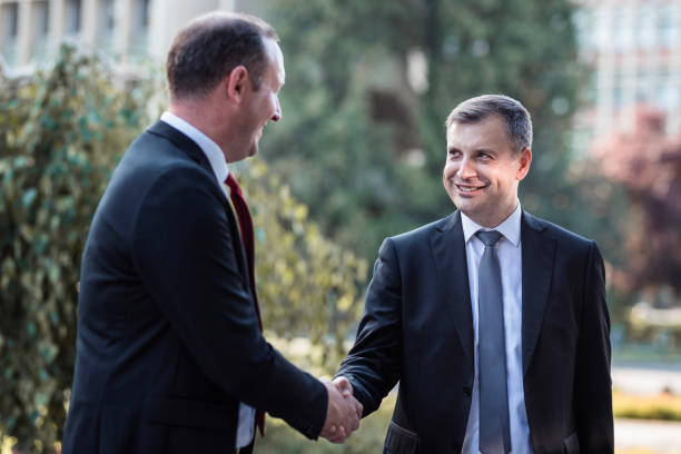 istock Business men sharing a laugh and a handshake 1359118960