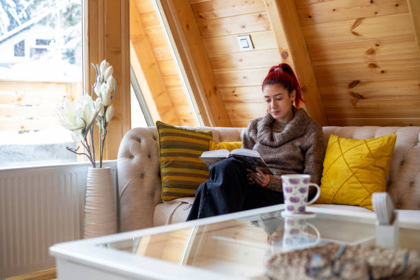 istock Young beautiful woman reading a book at home 1359118961