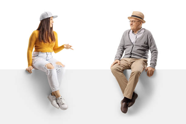 istock Elderly man listening to a young female seated on a blank panel 1359119085