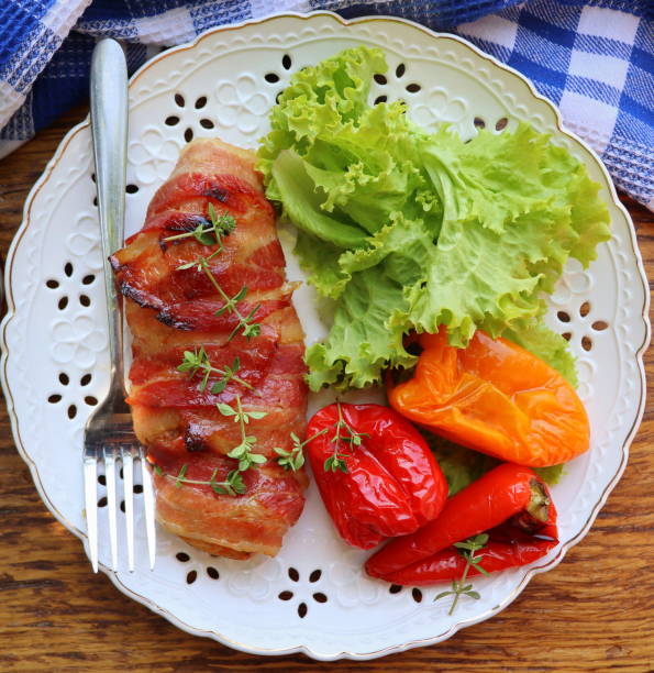 istock Dinner background. Grilled chicken breast wrapped in bacon in cooking pan on wooden rustic table . Top view 1359120651