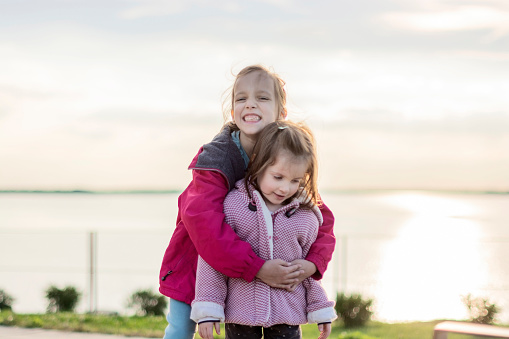 Two girls embracing outdoors