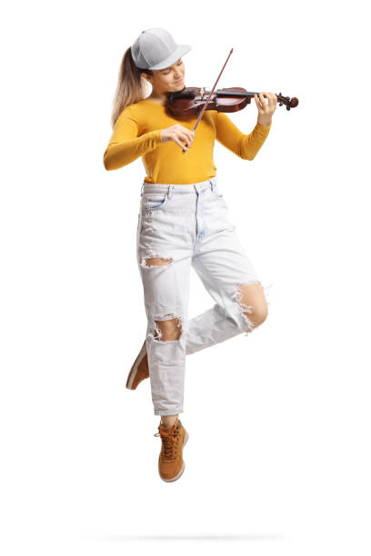 full length shot of a young female violinist in trendy clothes playing a violin and jumping - violin women violinist music imagens e fotografias de stock