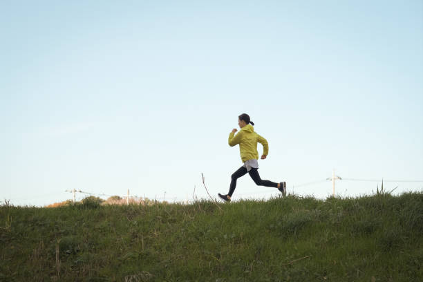 istock Young woman running on the riverbank 1359127013