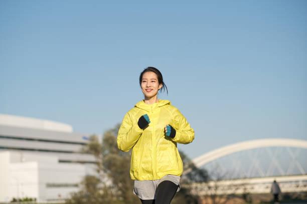 istock Young woman running on the riverbank 1359127624