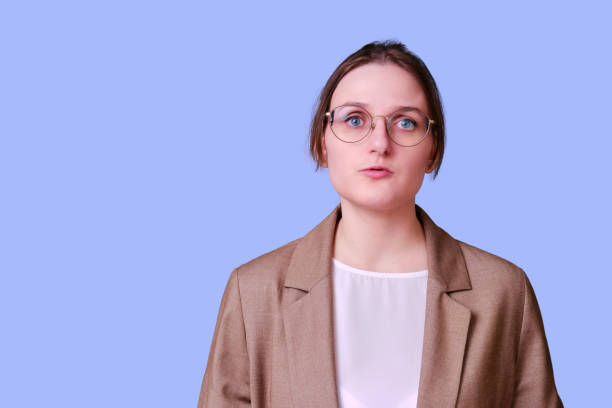 istock Woman teacher offendedly speaks on studio purple background, copy space 1359128738