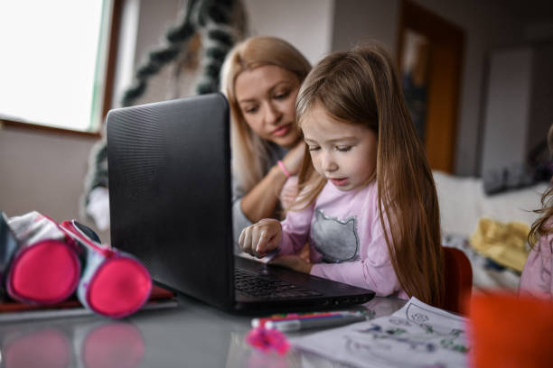 istock Mother Caring About Child Daughter's Hair While She's Using Laptop 1359131906