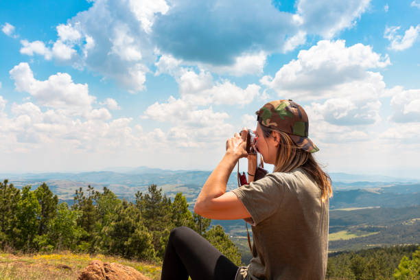 tourist girl photographing with vintage photo camera at the top of the mountain peak - tourist photographing armed forces military imagens e fotografias de stock