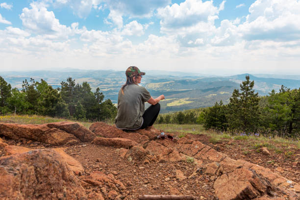 tourist girl hiker, photographer resting at the top of the mountain and enjoying amazing landscape view of mountains and beautiful sky - tourist photographing armed forces military imagens e fotografias de stock