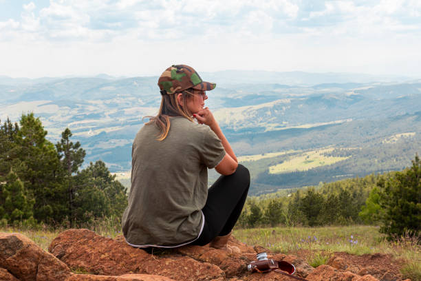 tourist girl hiker, photographer resting at the top of the mountain and enjoying amazing landscape view of mountains and beautiful sky - tourist photographing armed forces military imagens e fotografias de stock