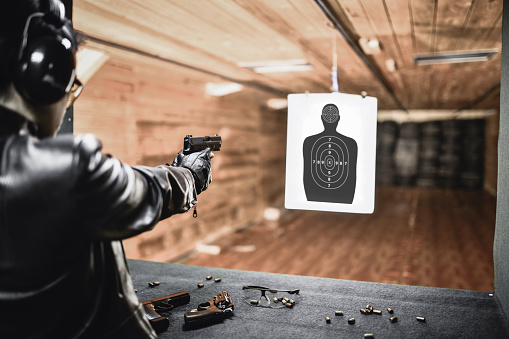 Práctica de tiro rápido de objetivo cercano por un hombre moderno con pistola en el rango photo