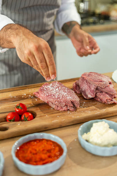 istock A close-up of a chef adding spices into a piece of meat 1359134607