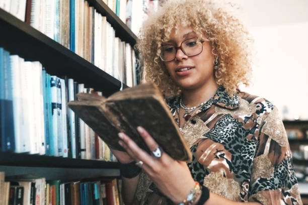 young woman reading in old book in library