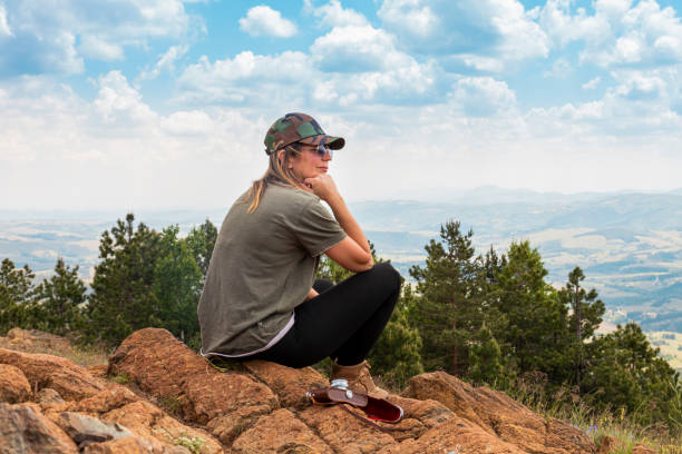 tourist girl hiker, photographer resting at the top of the mountain and enjoying amazing landscape view of mountains and beautiful sky - tourist photographing armed forces military imagens e fotografias de stock