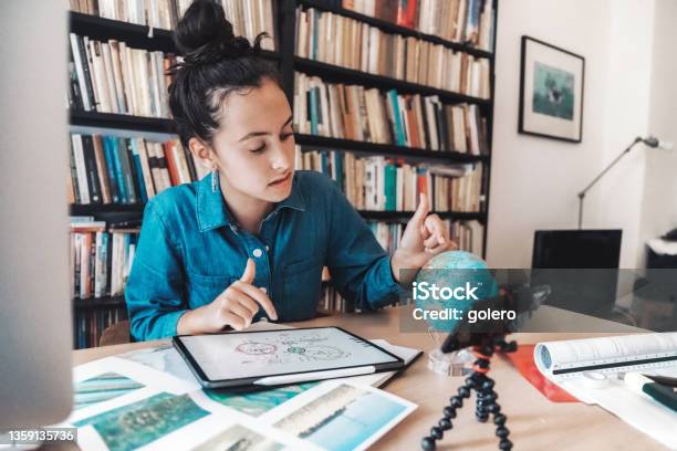 Teenage Girl Preparing Presentaion For Climate Change Issues On Digital Tablet And Globe Stock Photo - Download Image Now
