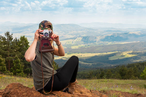 tourist girl photographing with vintage photo camera at the top of the mountain peak - tourist photographing armed forces military imagens e fotografias de stock