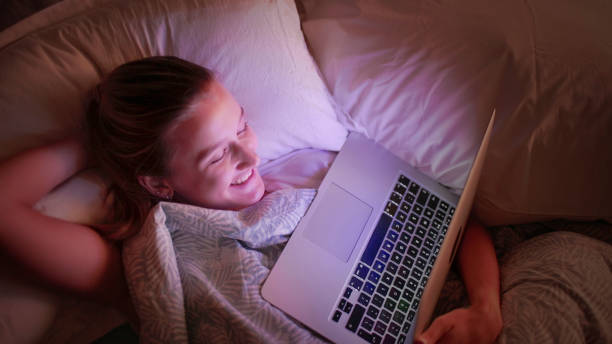 watching laptop bed - night school imagens e fotografias de stock