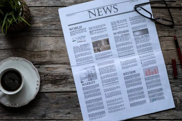 Photo of daily newspaper over wooden table
