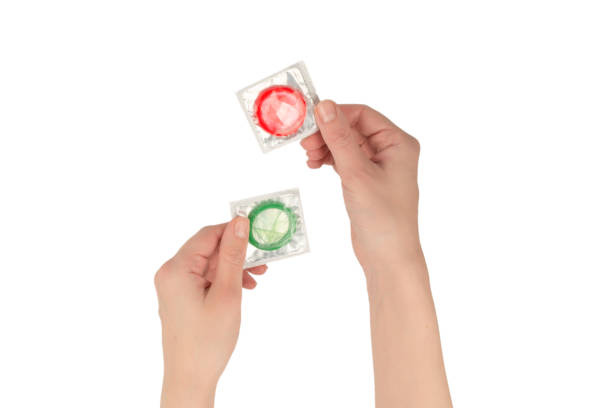 istock Condom in woman hand isolated on white background. 1359141414